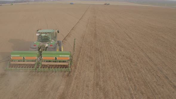 Aerial view of farm tractor working in field. 