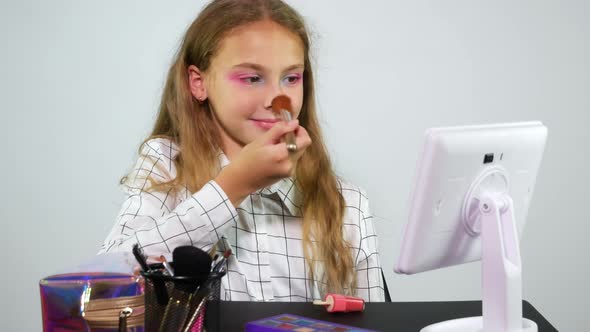 Smiling Teen Uses Powder Brush and Looks into the Mirror. Kid Cosmetology and Beauty.