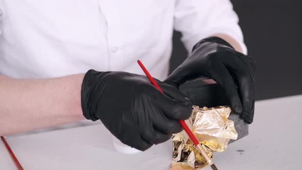 Closeup of Hands in Gloves Holding Brush and Coloring Pot