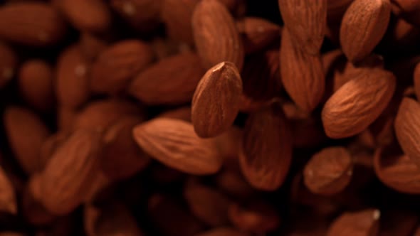 Super Slow Motion Shot of Almonds Flies After Being Exploded Against Black Background 1000Fps