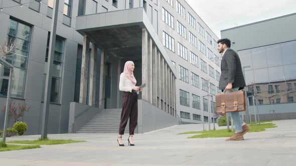 Side View of Muslim Business Partners in Formal Clothes Standing on Street and