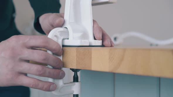 Man Fixes Domestic Flour Grinder on Wooden Table Closeup