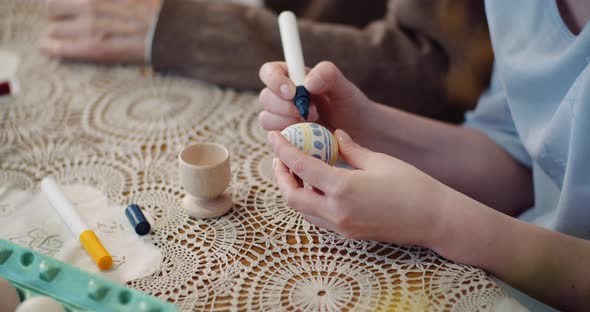 Hands Coloring Easter Eggs with Colors and Brush.