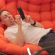Man Looking at Photos on the Phone While Lying on the Couch - VideoHive Item for Sale