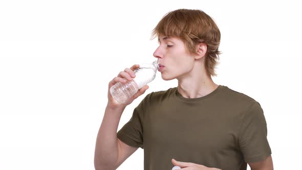 Portrait of Healthy Man 20s in Green Tshirt Drinking Still Water From Plastic Bottle Being