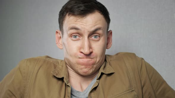 Angry Man in Mustard Jacket Gets Irritated Clenching Fists Standing on Grey Background