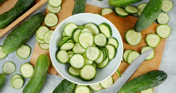 Round Slices of Fresh Cucumber Fall Into the Bowl. 