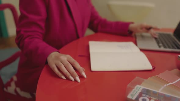 Woman in red business suite is tapping her fingers and brainstorming about business ideas in front o