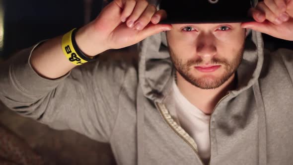 Portrait of a young man with a hat, beard, and hoodie sweatshirt