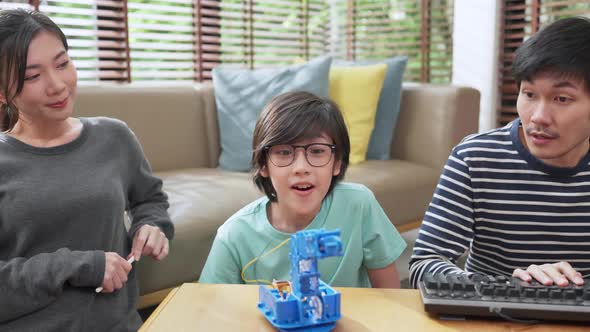 , happy family getting a lesson in coding control robotics at home