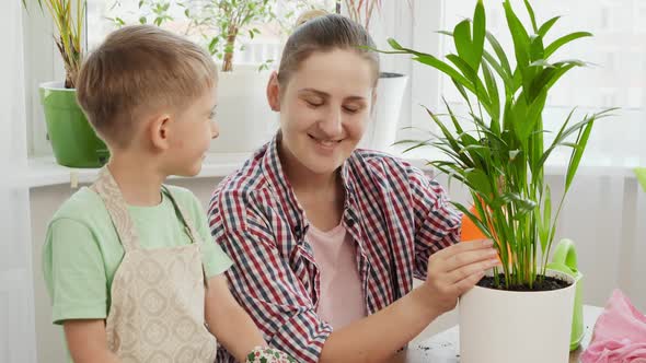 Smiling Mother Teaching Her Son Taking Care of Flowers and Plants at Home