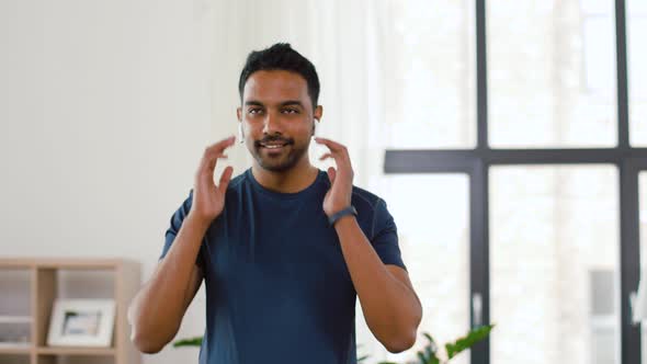 Man with Wireless Earphones Exercising at Home