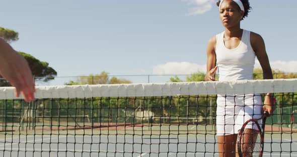 Video of african american female tennis player holding racket and shaking hand with friend