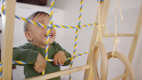 Happy Asian Toddler Playing on Indoor Gym and Smiling