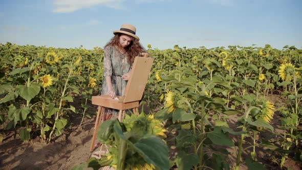 Excellent View of a Beautiful Girl Who Paints a Landscape in the Sunflower Field