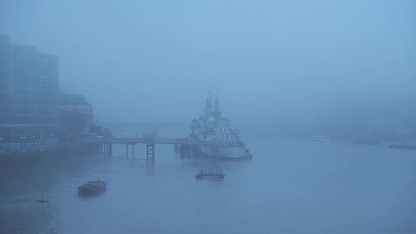 Foggy and misty River Thames and HMS Belfast in London on Coronavirus Covid-19 lockdown day one, in 