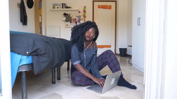 Young woman sitting on the floor using laptop at home