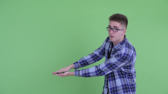 Happy Young Hipster Man Snapping Fingers and Showing Something