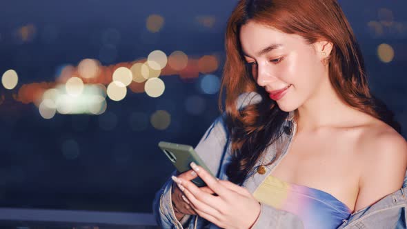 Portrait of smiling pretty young  woman using phone on rooftop