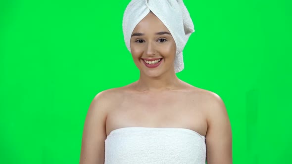 Attractive Woman with Bare Shoulders and White Towel on Her Head Standing with Smile in the Green