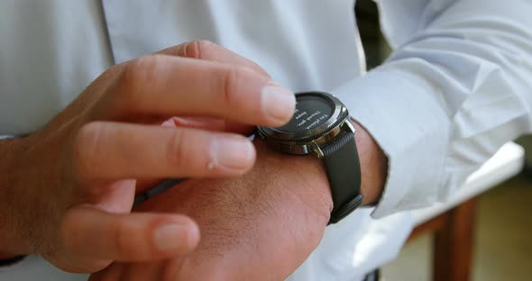Male executive using smartwatch in office 