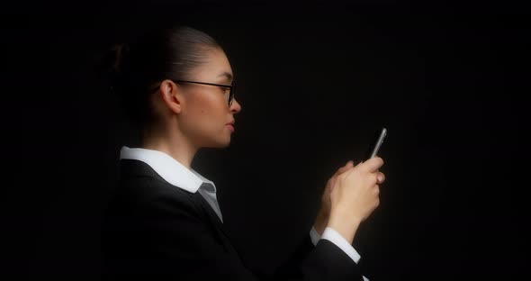 Business Woman Stands in Profile Communicates in Messenger