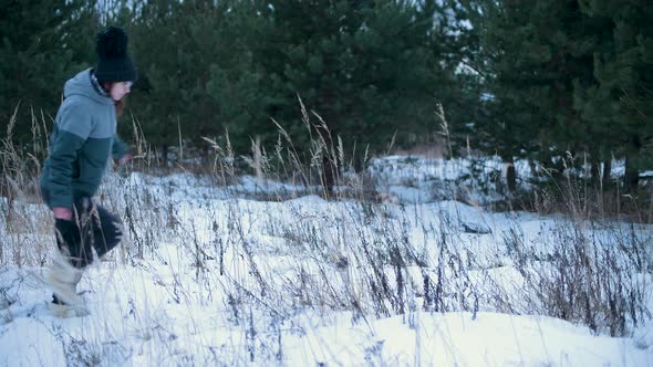 Girl walks across the field on a winter evening