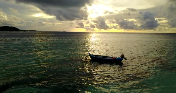 Wide angle drone travel shot of a white sandy paradise beach and blue sea background in colorful 