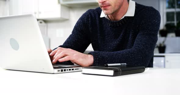 Man using laptop in the kitchen