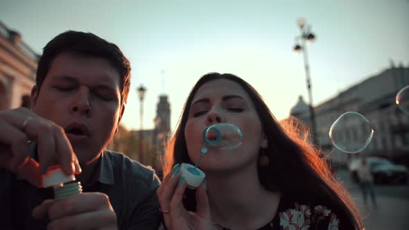 Love and Soap Bubbles Blowing By Male and Female Young Married Couple.