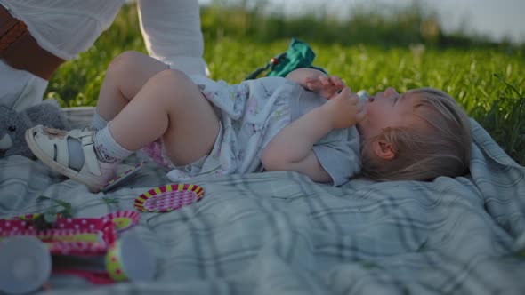 Little Baby Infant Girl Crying at an Outdoor Picnic.