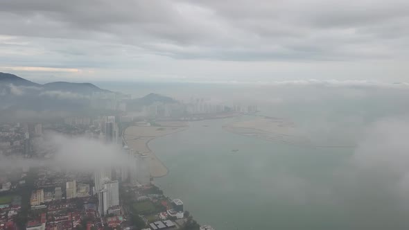 Aerial fly over low cloud. Back is reclamation land