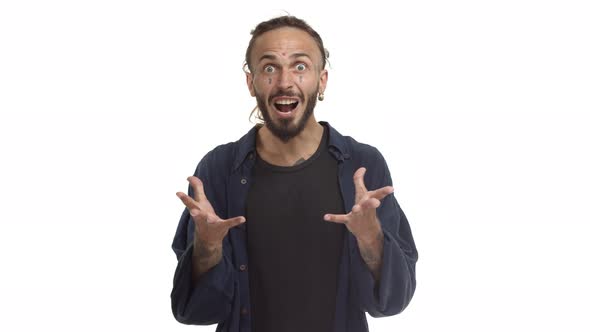 Studio Shot of Handsome Hipster Guy with Beard and Tattoos on Face Looking Shocked Asking What and