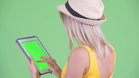 Closeup Rear View of Happy Young Blonde Tourist Woman Using Digital Tablet