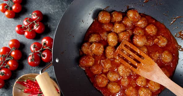 Meatballs Are Fried in a Pan with Tomatoes. 