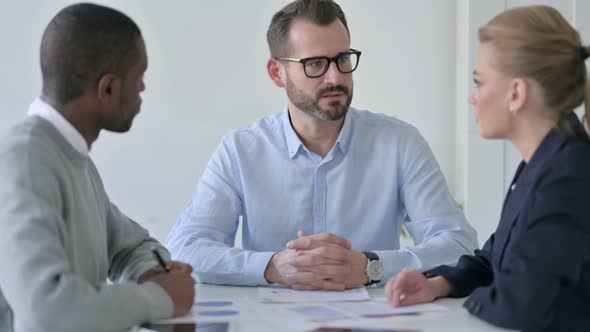 Serious Businessman Talking to Business People in Office