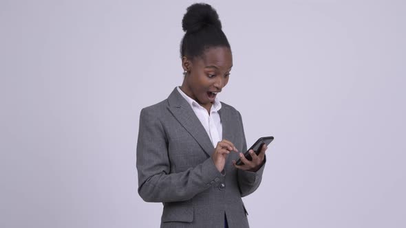 Young Happy African Businesswoman Using Phone and Getting Good News