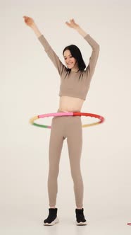 Young Fit Woman Twisting Hula Hoop Isolated