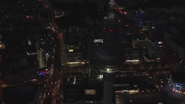 AERIAL: Close Up of Berlin Germany TV Tower Alexanderplatz at Night with City Lights Traffic 