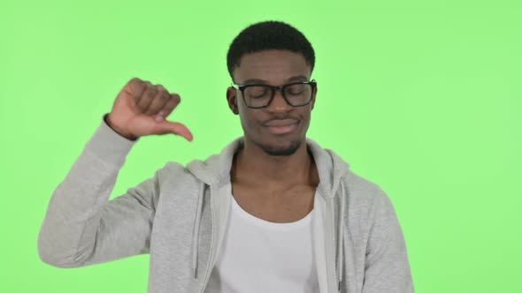 Thumbs Down Gesture By African Man on Green Background