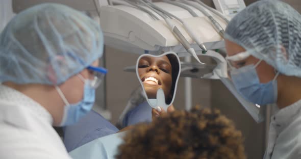 Reflection in Mirror Healthy Smile of Pretty Young Female Patient in Dental Clinic