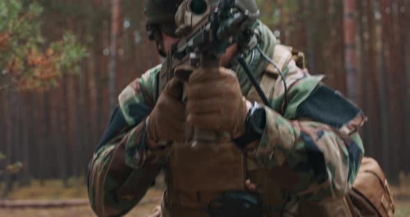 A Bearded Soldier in a Tactical Military Uniform with a Helmet on His Head and with a Sniper Rifle