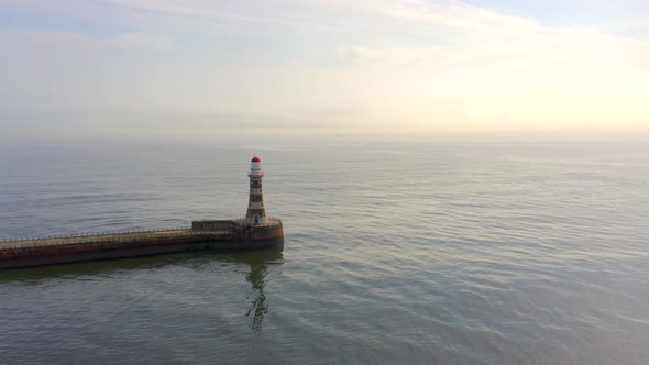 A Lighthouse and Pier in the Early Morning