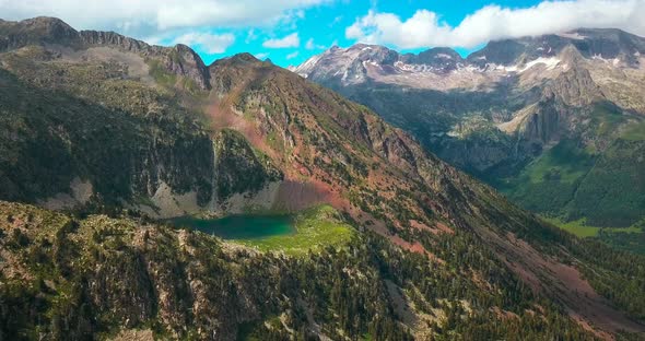 Aerial horizontal 4K footage of a lake in the top of a mountain in the Spanish Pyrenees.