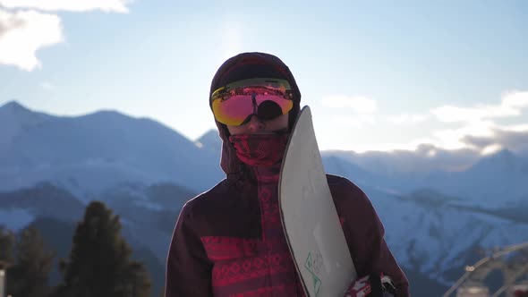 Girl Snowboarder with Snowboard on Mountain Top on Ski Resort. Winter Sports and Winter Vacation