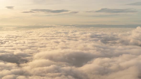 Time lapse of aerial view of sunset above fluffy sea fog misty clouds