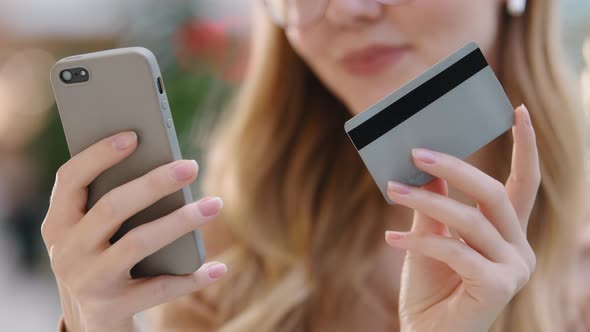 Closeup Hands Young Caucasian Girl Holding Phone and Credit Card Woman Buyer Make Internet Order