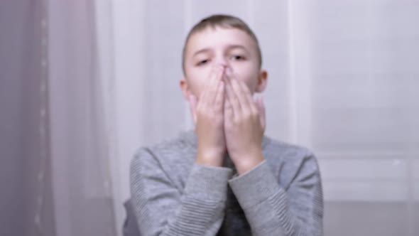 Cheerful Smiling Caucasian Boy Blowing a Kiss While Stretching His Hand Forward