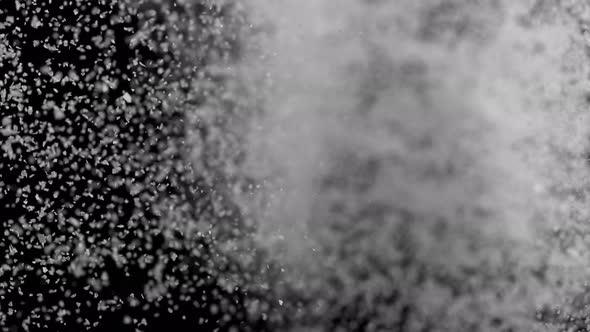 Camera follows throwing kosher salt into water. Slow Motion.