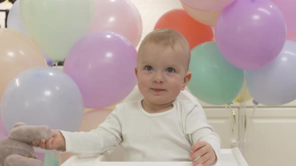 Happy Little Boy Holding Gift Toy at Birthday Party in Slow Motion One Year Old Kid Against Colorful